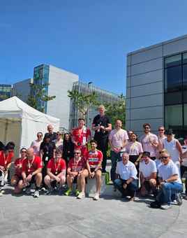 Winners on podium holding medals and sweets at Apple’s summer sports day