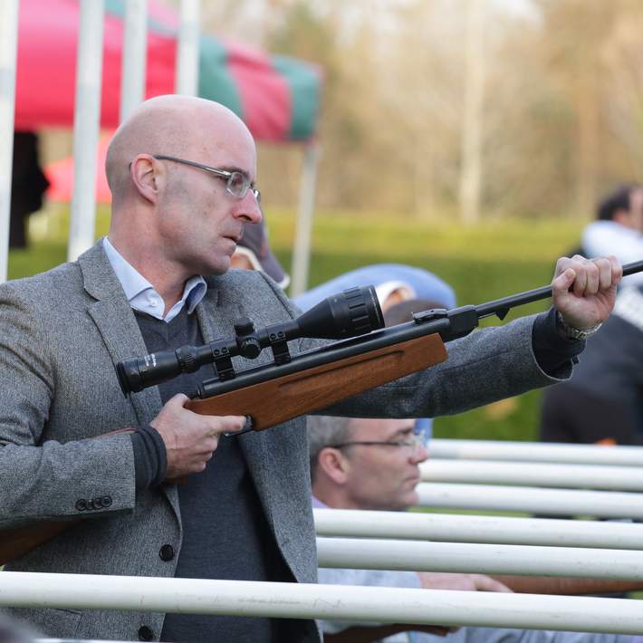 man loading pellet into air rifle