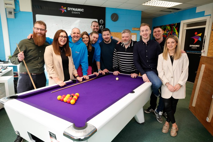 team standing behind pool table