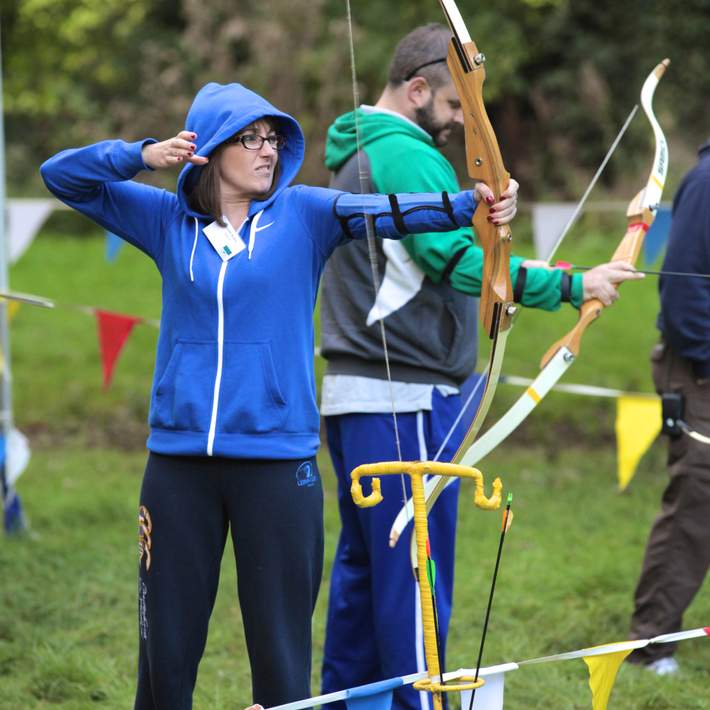 woman firing arrow from bow