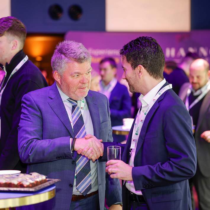 men networking and shaking hands at a conference 