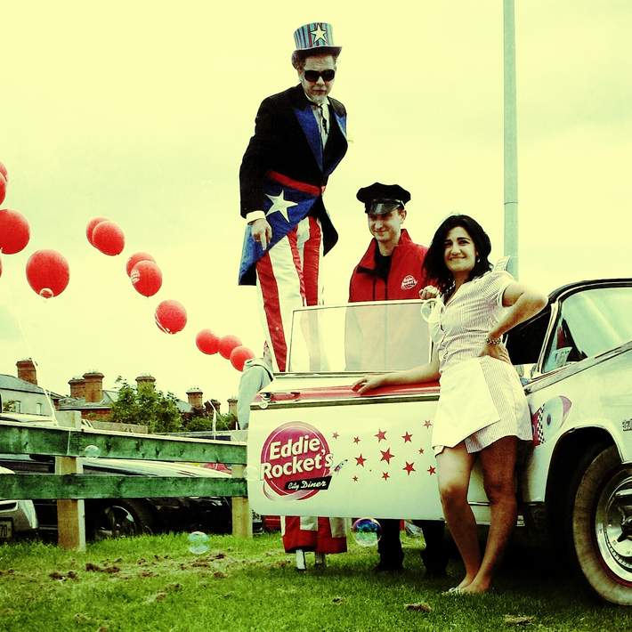 stilt walker with car