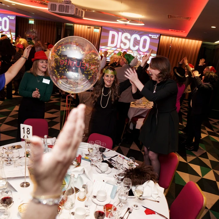 Corporate team enjoying Disco Bingo at a lively team building event with music, party games, and dancing at a hotel venue in Ireland