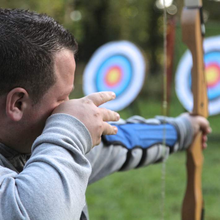 man firing arrow from bow