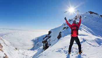 Mountaineer walking uphill along a snowy slope