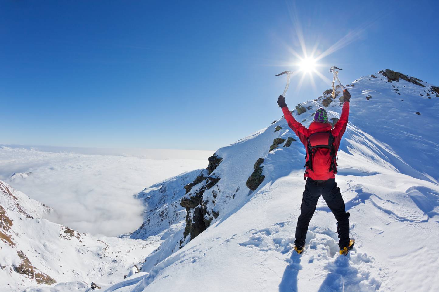 Mountaineer walking uphill along a snowy slope