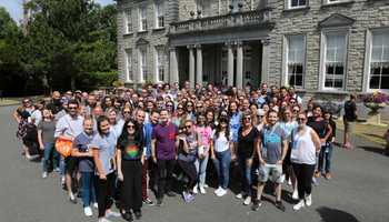 group of people standing in front of manor house