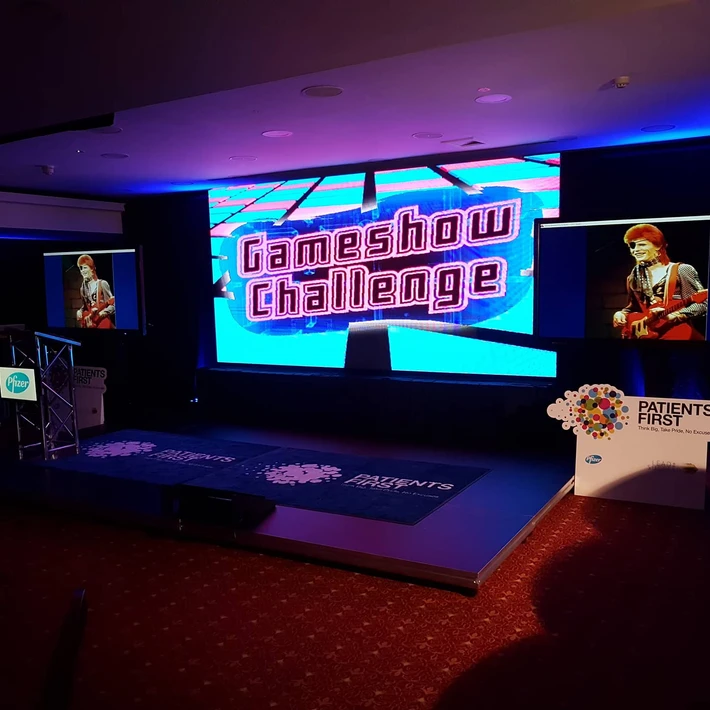 Gameshow Challenge set with podiums, lighting, and large screen