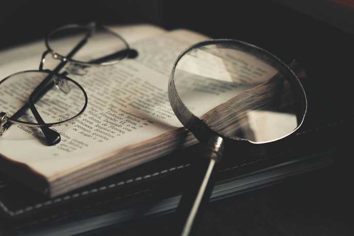 murder mystery with a book and a magnifying glass