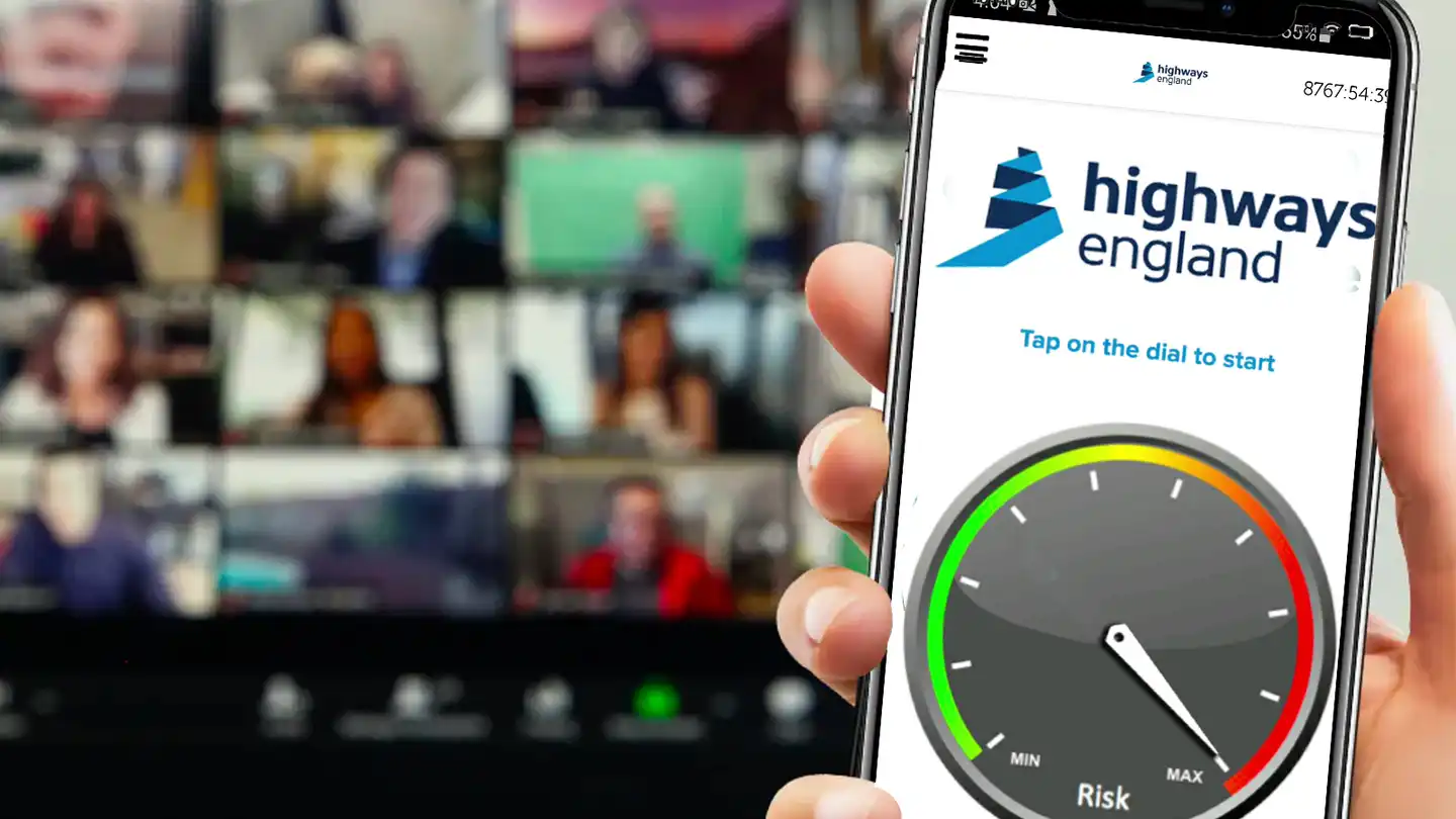 person holding phone with custom game screen in front of video conference call