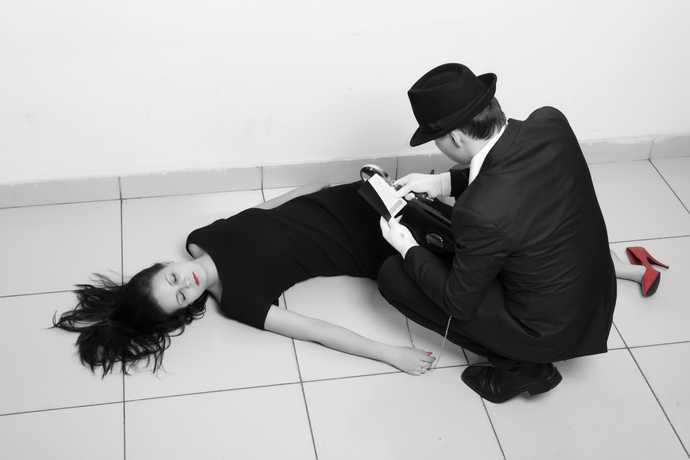 woman lying on floor with detective looking over her