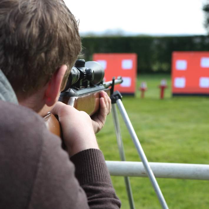 man aiming air rifle at targets