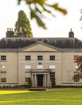 Avondale House pictured through the trees on a plain of grass