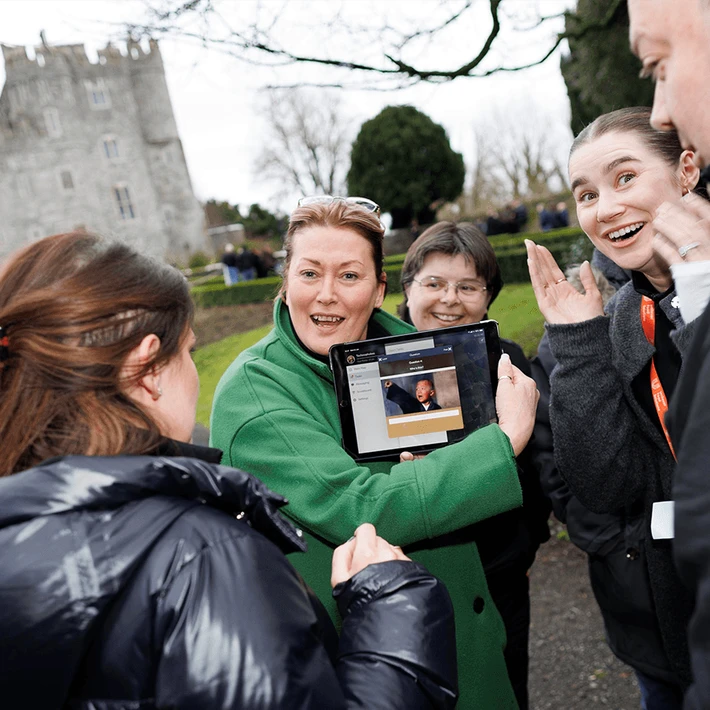 Corporate team enjoying a Venue Adventure digital treasure hunt on hotel grounds in Ireland, using an iPad to complete GPS challenges