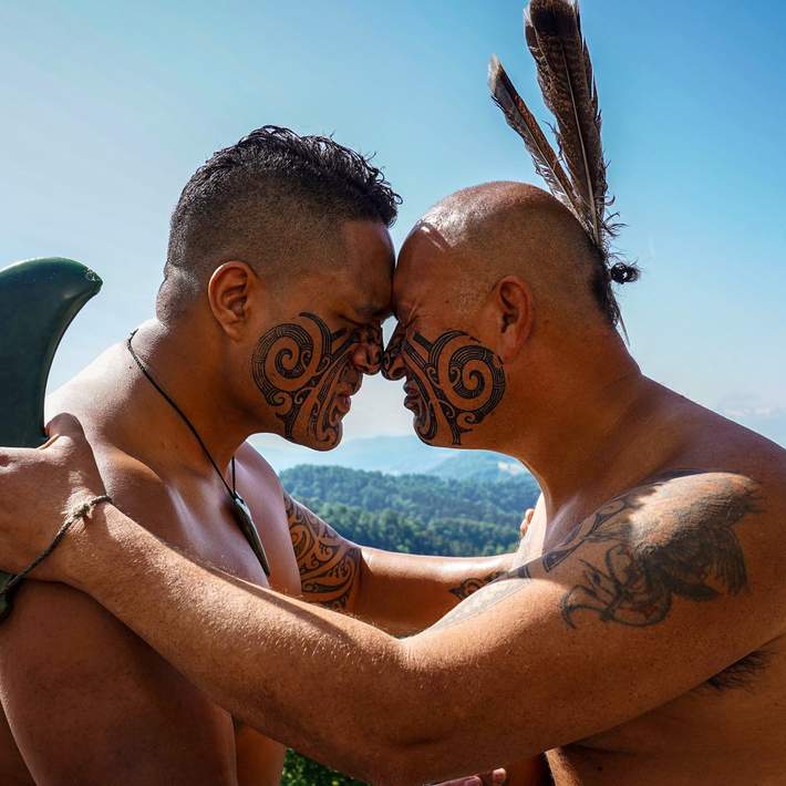 two maori men greeting each other