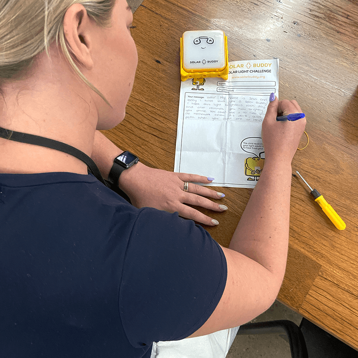 woman writing a letter as part of solarbuddy event