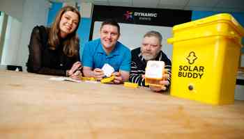 Employees engaged in assembling solar lights during a SolarBuddy activity for communities without electricity