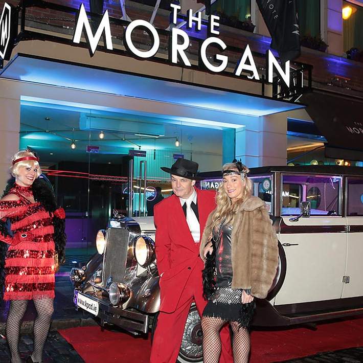 3 people with vintage car outside the morgan hotel at launch event