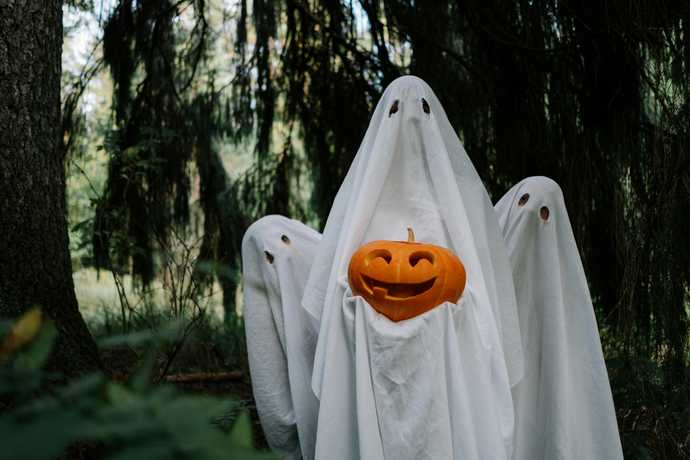 Three Ghosts Holding a pumpkin in the forest