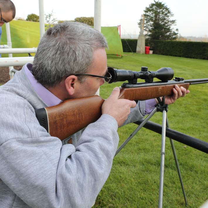 man looking through scope on air rifle