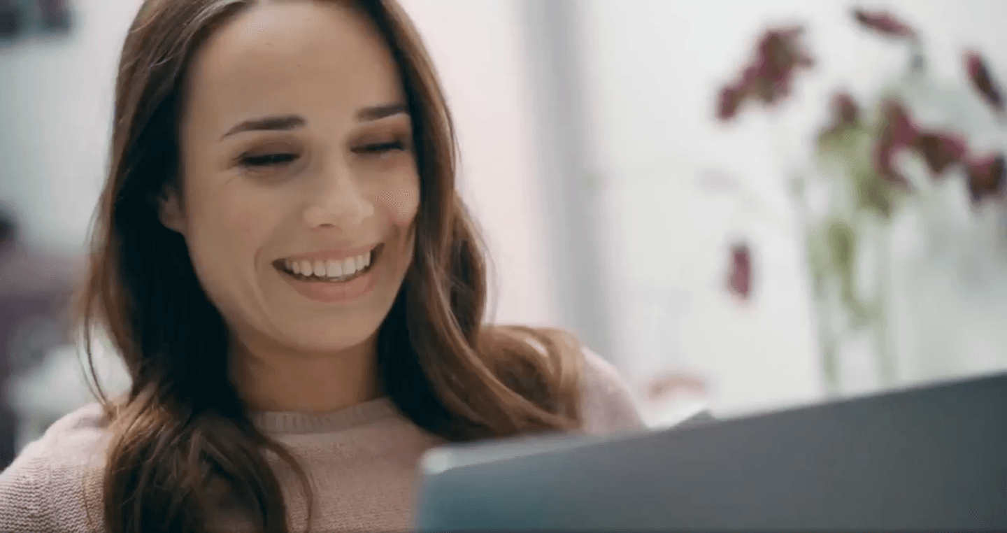 woman smiling at laptop screen