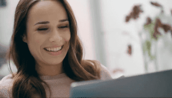 woman smiling at laptop screen